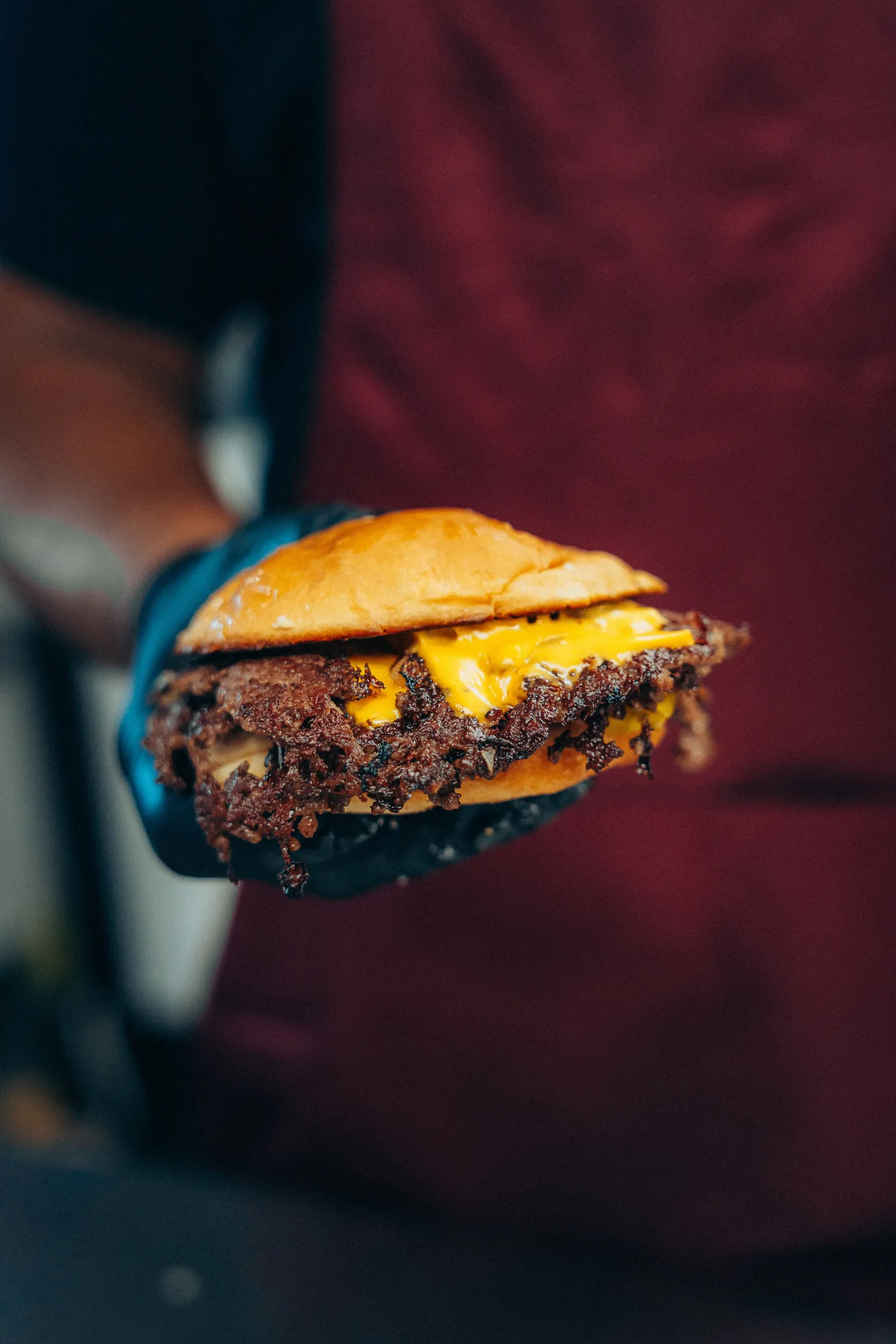 A smash cheeseburger with melted cheese, up close