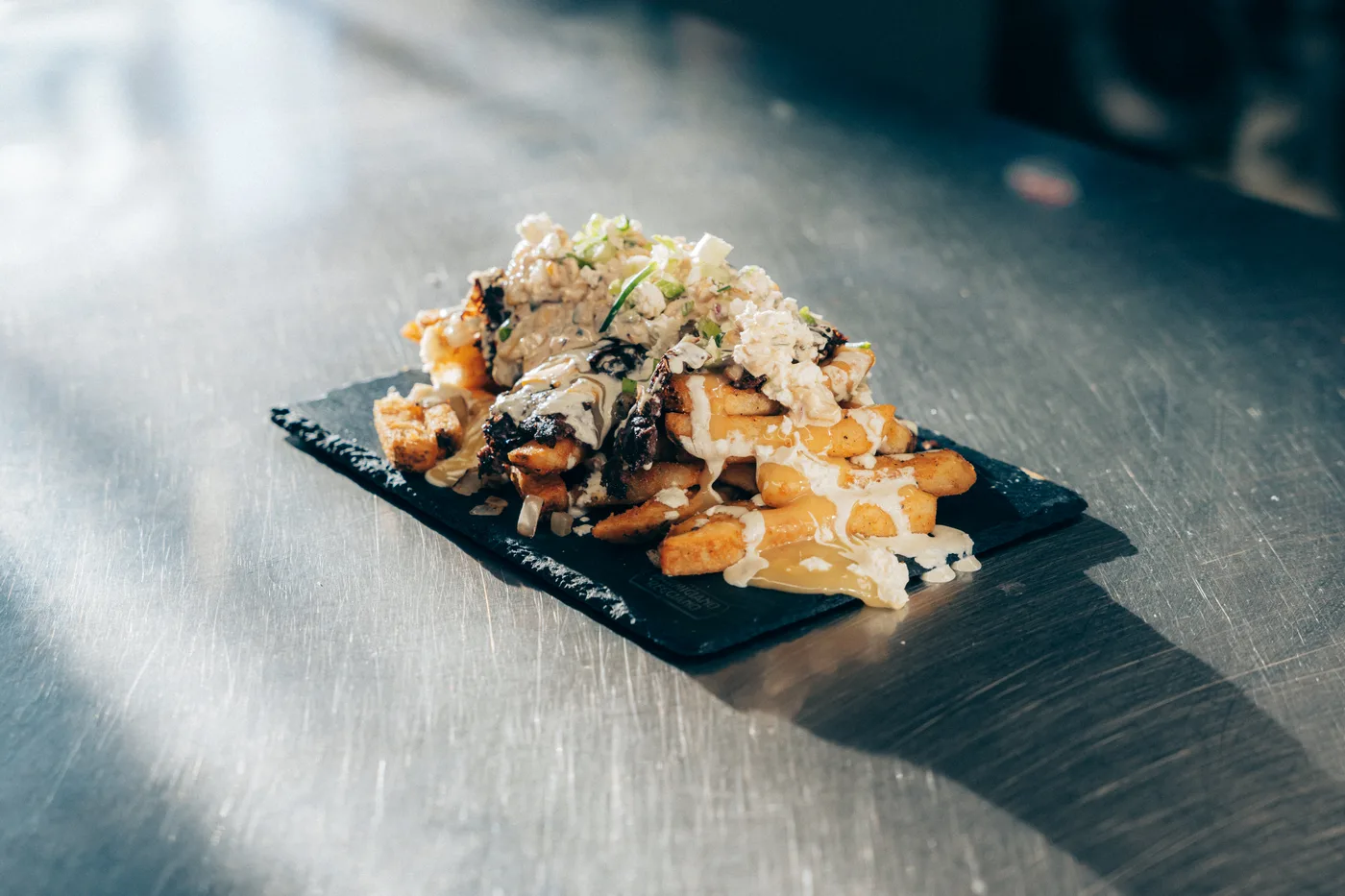 A loaded poutine on a slate board